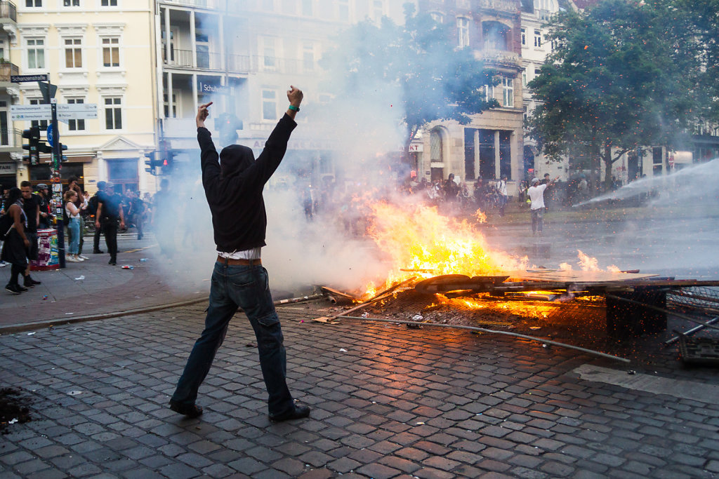 Rioter at a burning barricade